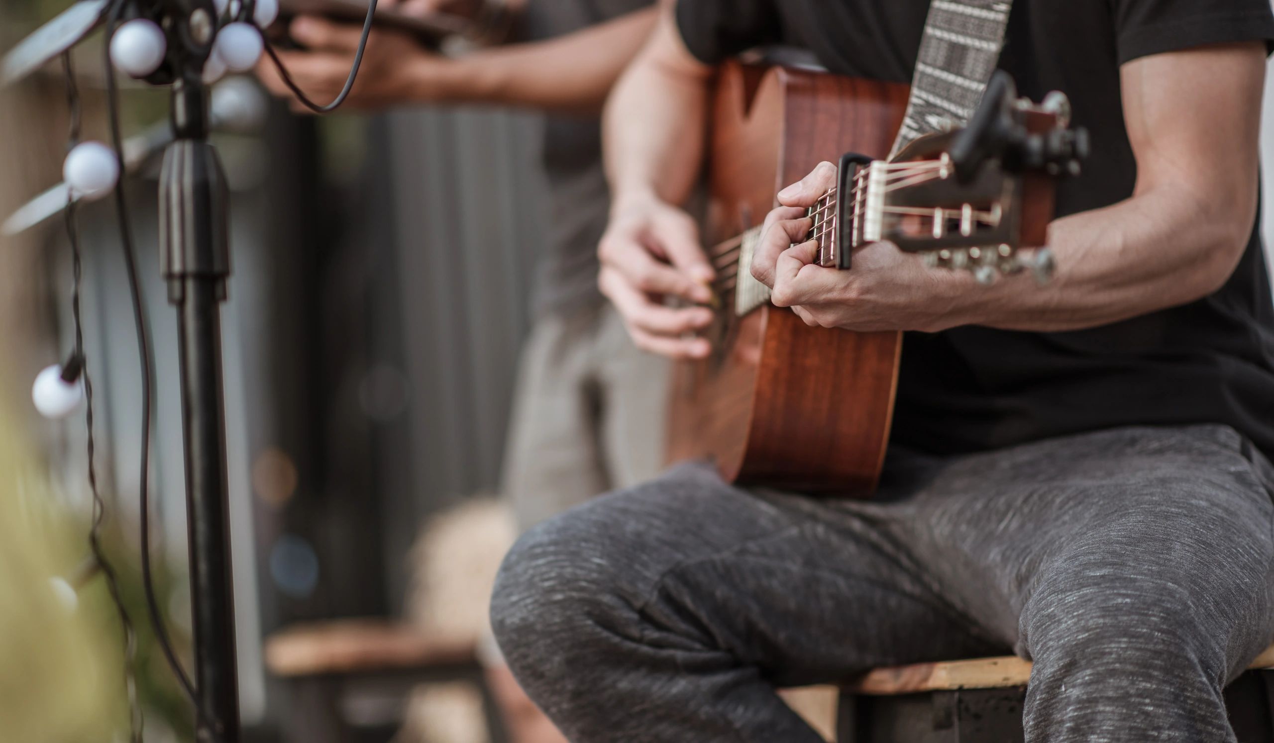 Close-up of hands playing an acoustic guitar during a live performance.