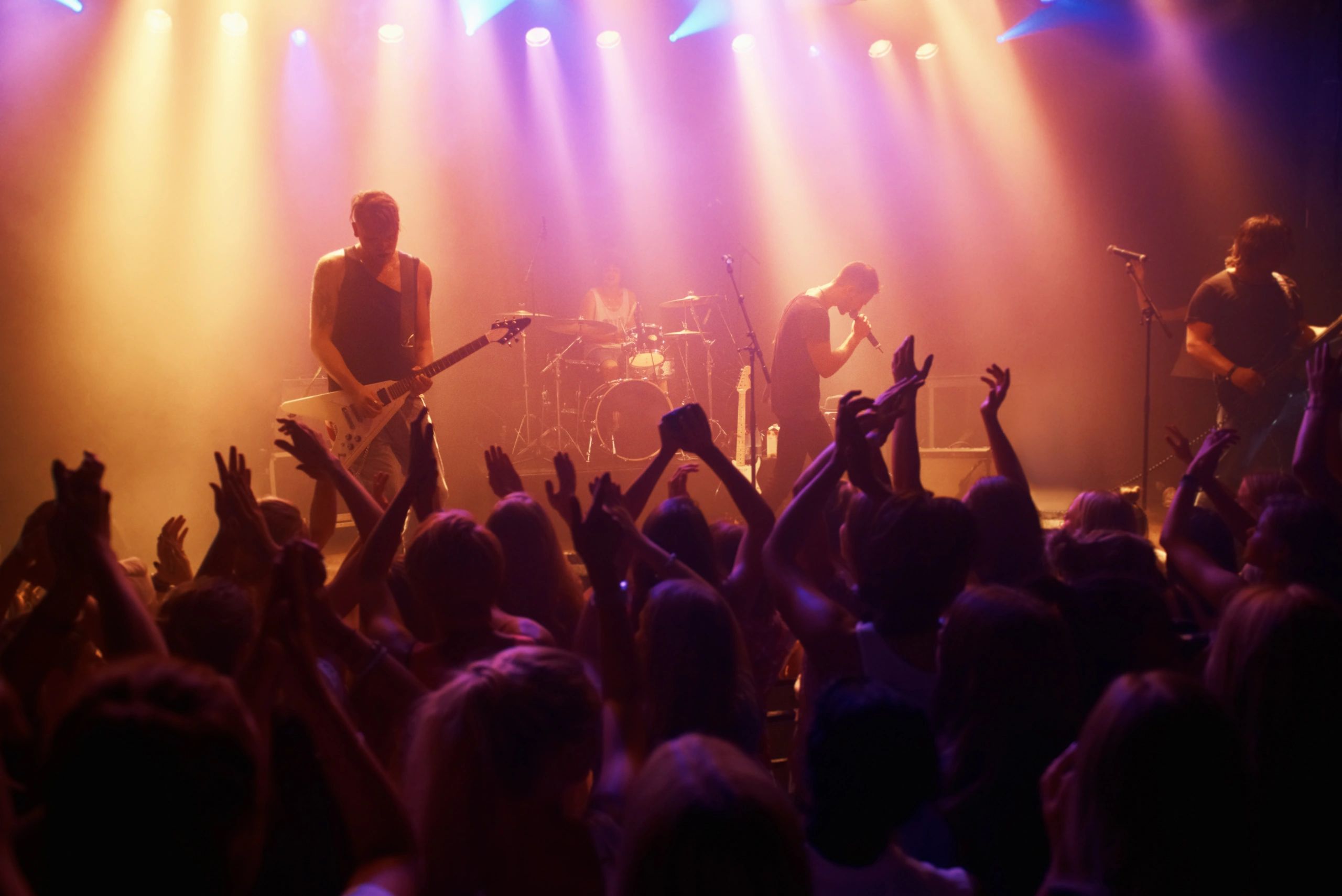 Energetic live concert with band playing and crowd cheering.